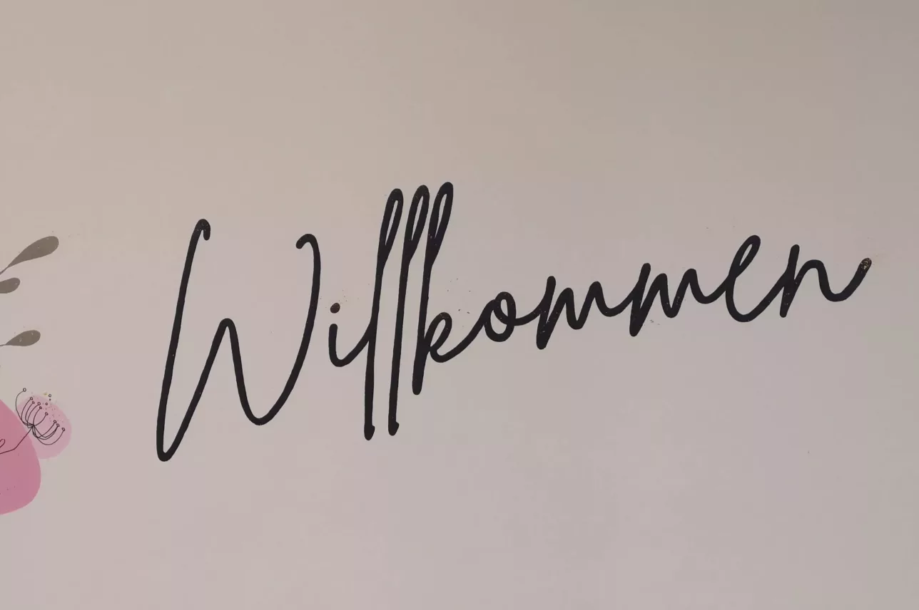 Wandzeichnung mit Blumen, Schmetterling und dem Schriftzug 'Willkommen' auf der Geburtshilfestation E12 den Johannes-Wesling-Klinikums in Minden.